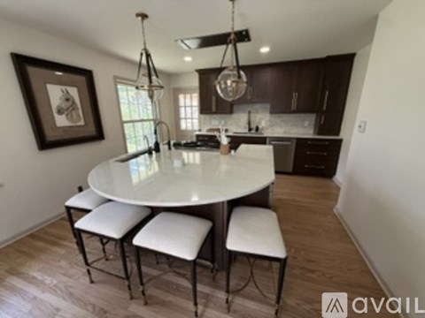 A modern kitchen with a large island and a dining table.