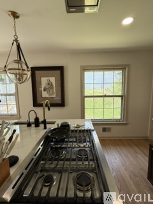 A kitchen with a stove top oven and a window.