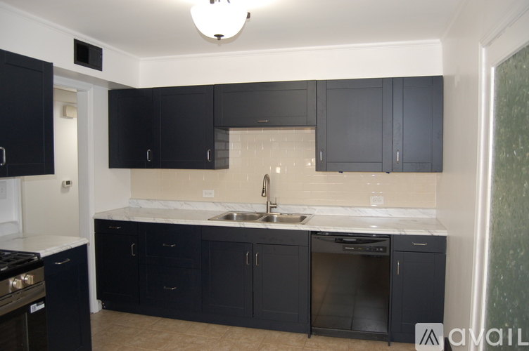 A kitchen with black cabinets and a white countertop.