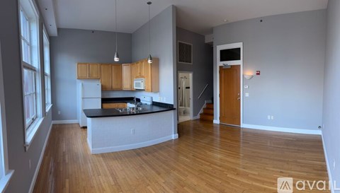 A kitchen with wooden cabinets and a black countertop is available for rent.