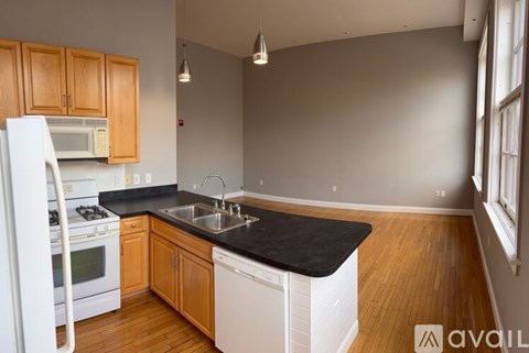 A kitchen with wooden cabinets and a black countertop.