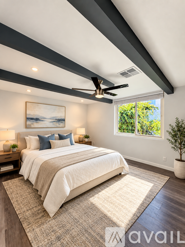 A bedroom with a large bed and a ceiling fan.