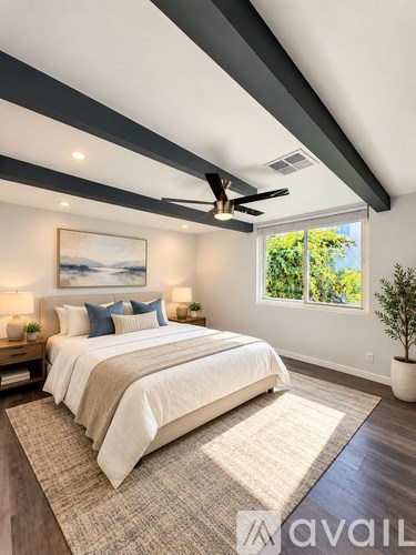 A bedroom with a large bed and a ceiling fan.