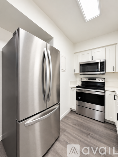 A modern kitchen with a stainless steel refrigerator and microwave above the stove.