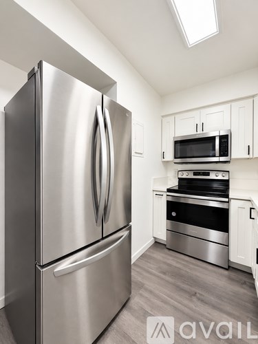 A modern kitchen with a stainless steel refrigerator and microwave above the stove.