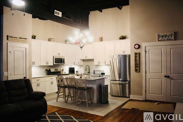 A kitchen with a black chair and a table with a sign on it.
