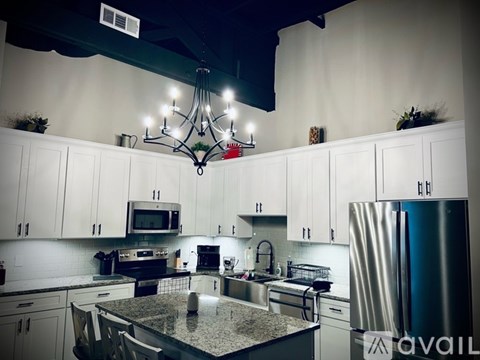 A kitchen with a granite countertop and stainless steel appliances.