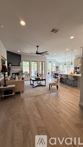 A spacious open-plan living and kitchen area with wooden flooring.