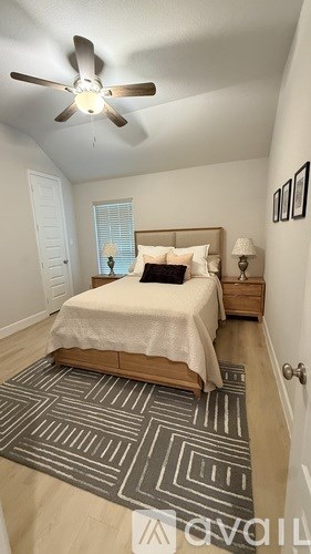 A bedroom with a bed, a ceiling fan, and a rug.