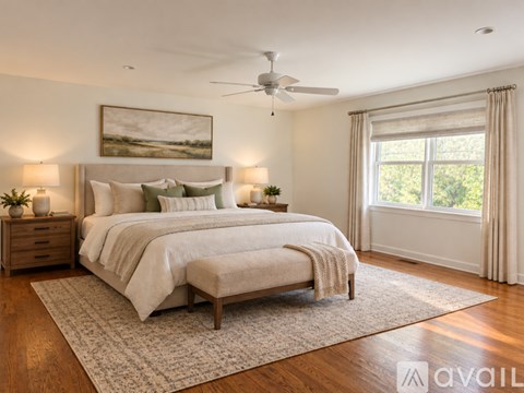 A bedroom with a large bed and a painting on the wall.