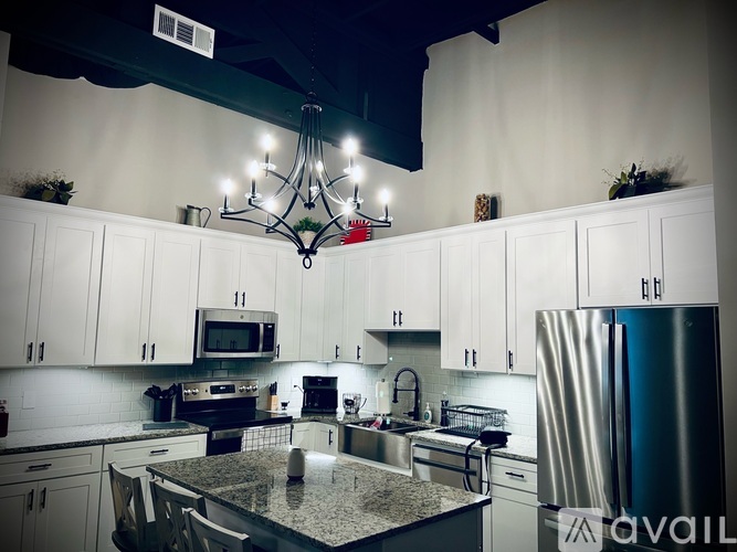 A kitchen with a granite countertop and stainless steel appliances.