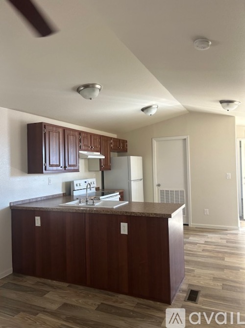A kitchen with brown cabinets and a white fridge.