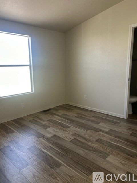 A room with a wooden floor and a window.
