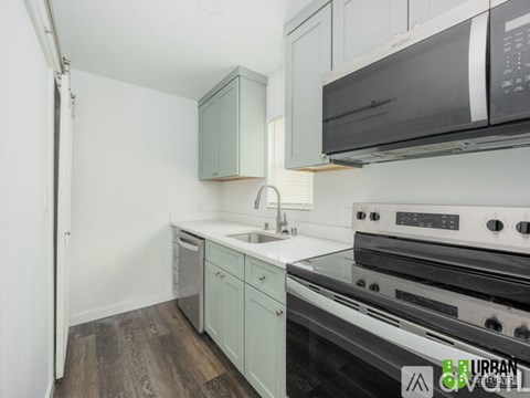 A kitchen with a stove top oven and a sink.