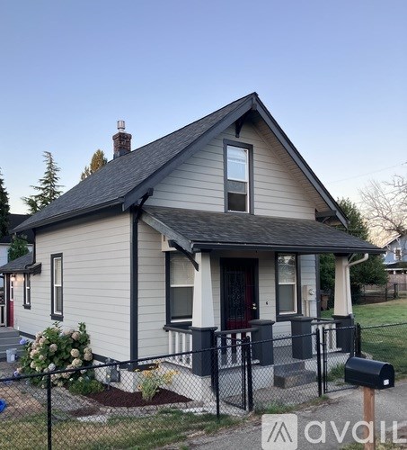 A small house with a black fence in front.