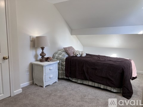 A bedroom with a bed, nightstand, and lamp.