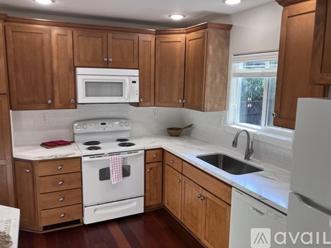 A kitchen with wooden cabinets and white appliances.
