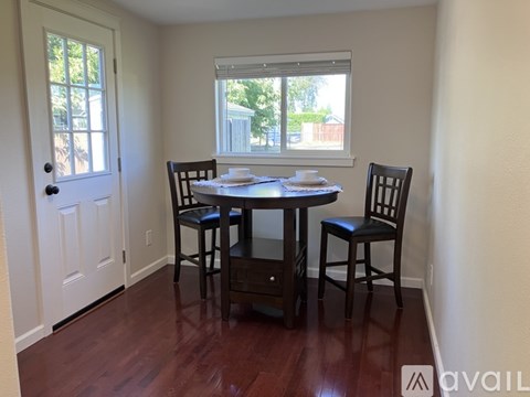 A dining room with a table set for two and a window.