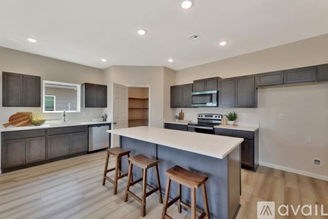 A modern kitchen with dark brown cabinets and a white island.