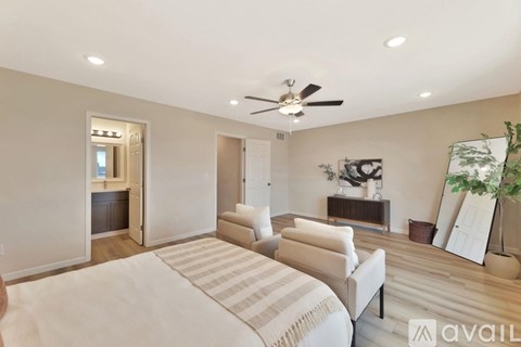A bedroom with a large bed and a ceiling fan.