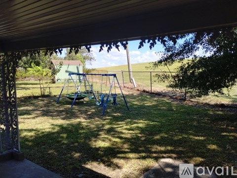 A playground with a swing set and a slide is visible through a covered patio.