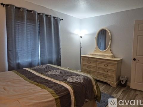 A bedroom with a bed, dresser, and mirror.