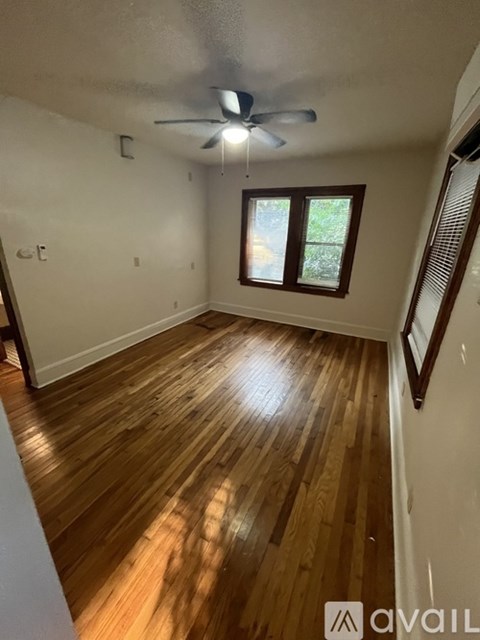 A room with wooden floors and a ceiling fan.