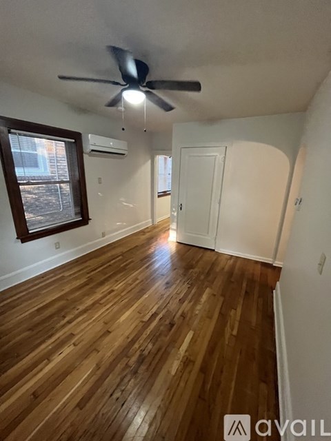A room with wooden floors and a ceiling fan.