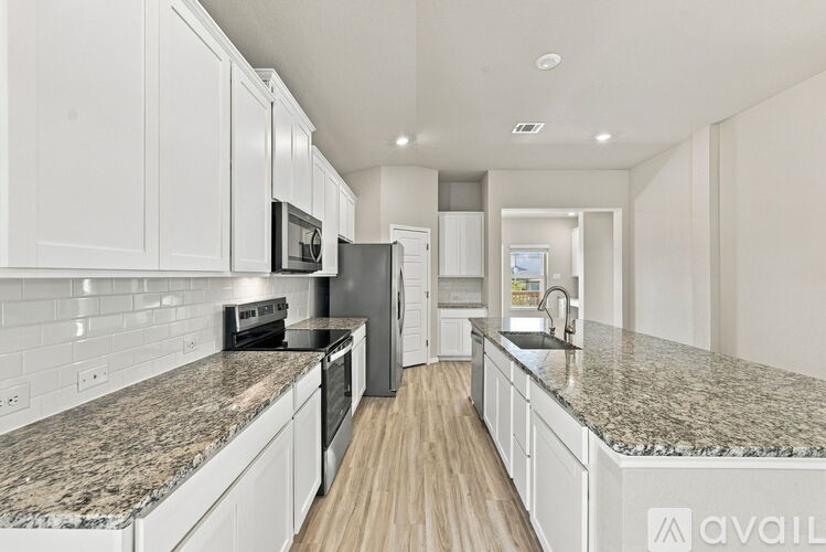A kitchen with granite countertops and white cabinets.
