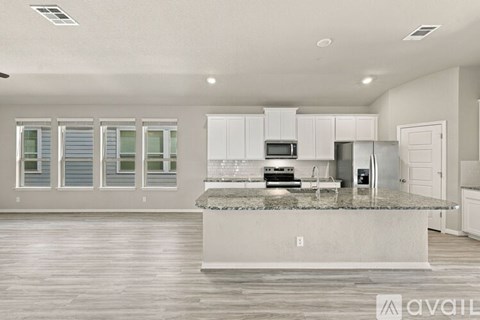 A kitchen with a granite countertop and white cabinets.
