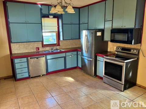 A kitchen with a refrigerator, oven, and sink.
