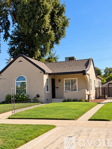 A house with a well-kept lawn and a clear sky above.