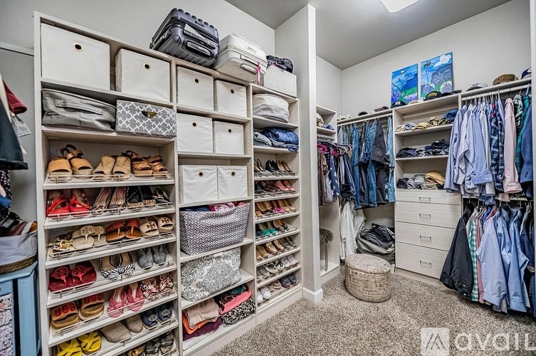 A spacious walk-in closet with organized shelves and drawers for shoes and clothes.