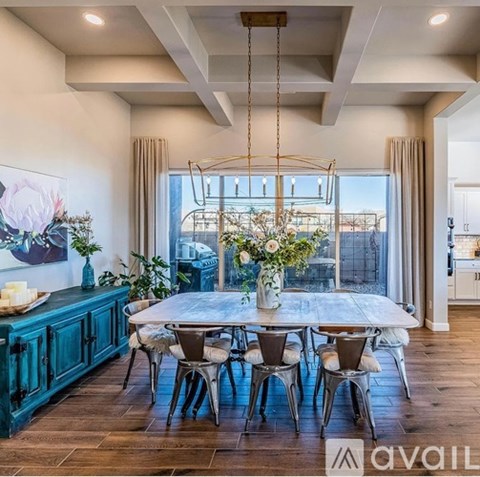A dining room with a large table and chairs.