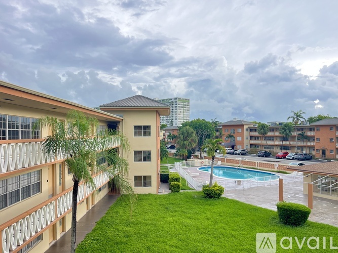 A view of a pool and apartment complex from a balcony.