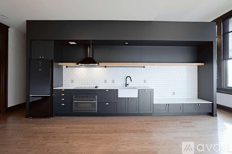 A modern kitchen with dark wood floors and a white subway tile backsplash.
