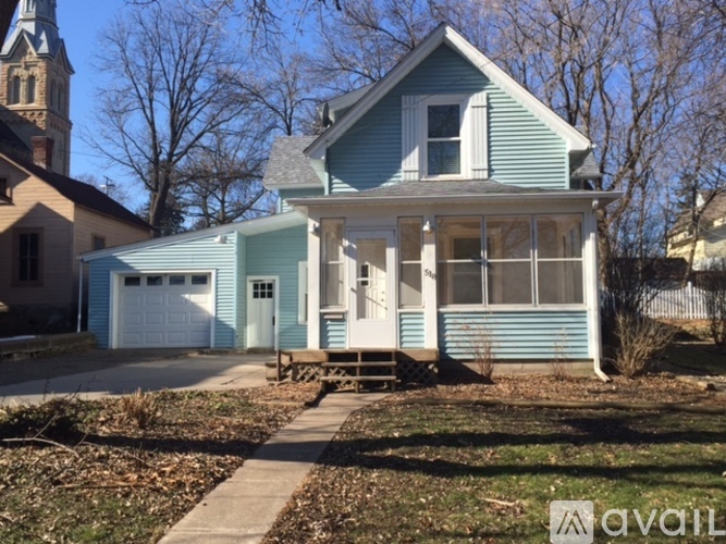 A blue house with a white garage door and a white porch.