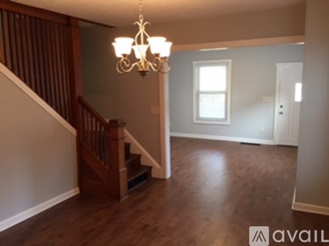 A chandelier hangs over a staircase in a house.