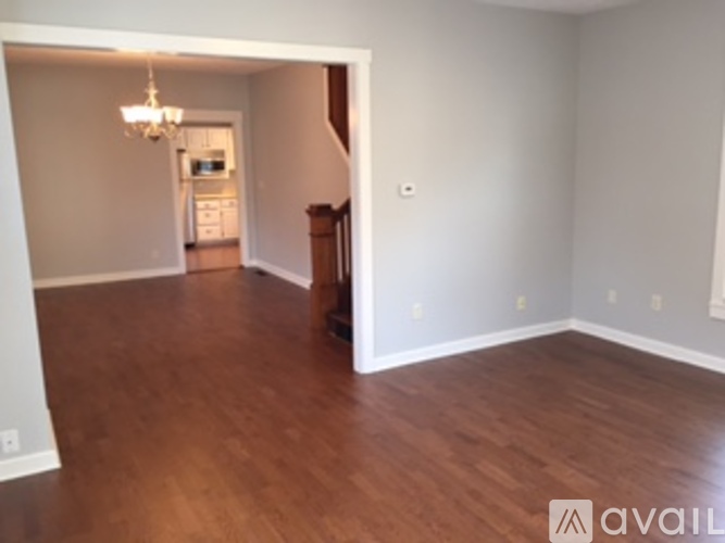A room with wood floors and a chandelier.