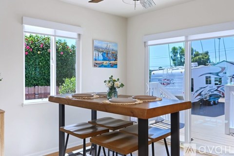 A dining room with a wooden table and chairs.