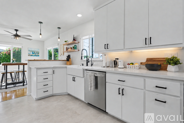 A modern kitchen with white cabinets and a marble floor.