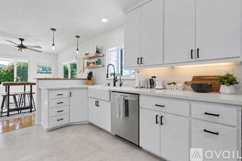 A modern kitchen with white cabinets and a marble floor.