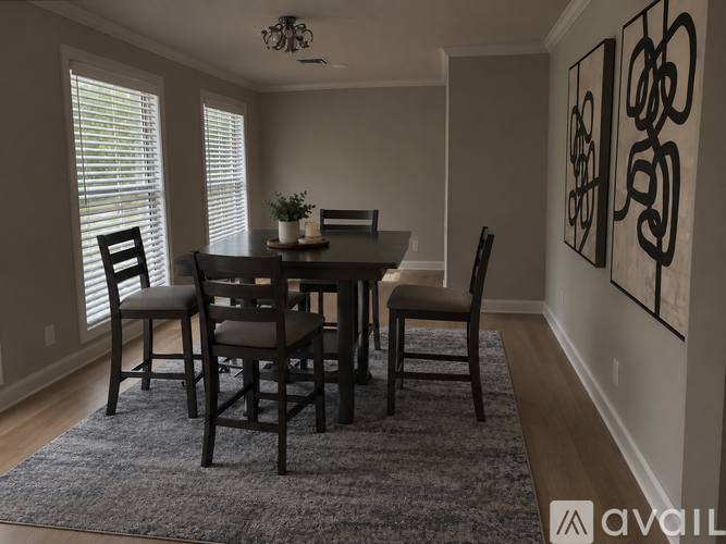 A dining room with a table and chairs.