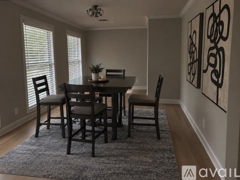 A dining room with a table and chairs.