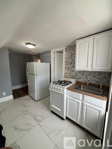 A kitchen with white appliances and cabinets.