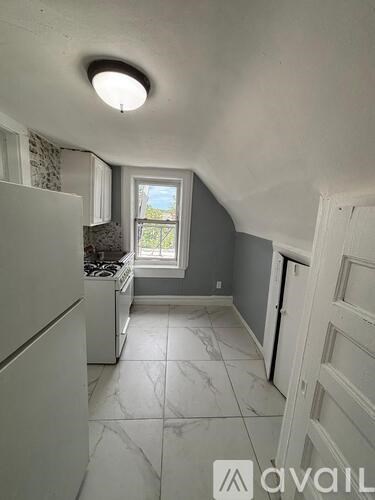 A kitchen with a white fridge and a window.