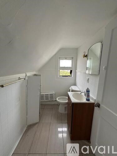 A small bathroom with a toilet, sink, and a window.