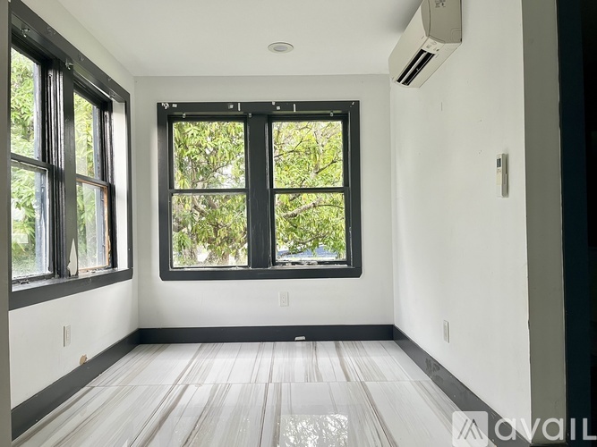 A room with a large window and wooden flooring.
