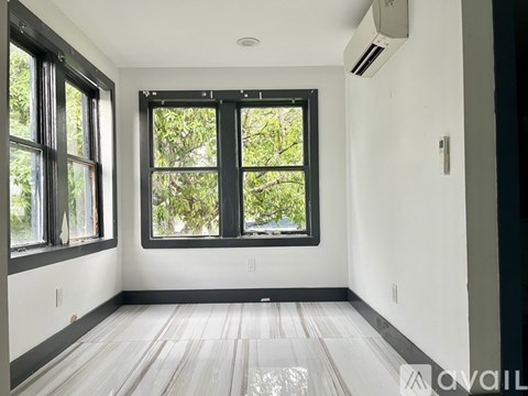 A room with a large window and wooden flooring.