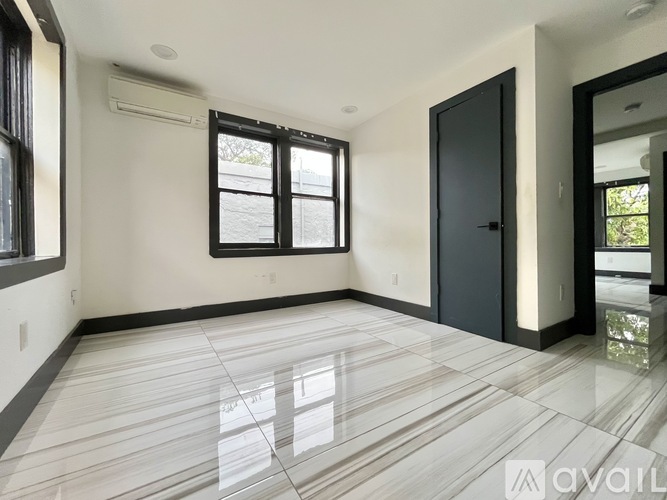 A spacious room with a tiled floor and a large window.